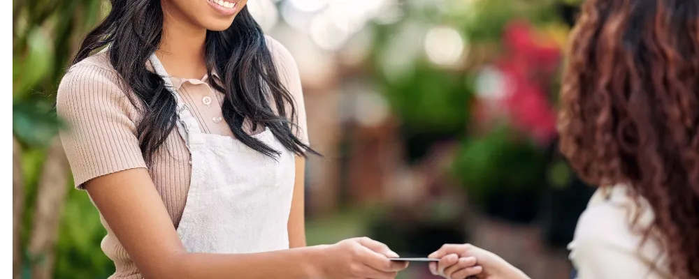 A credit card being handed to a merchant who will have to pay merchant account fees.