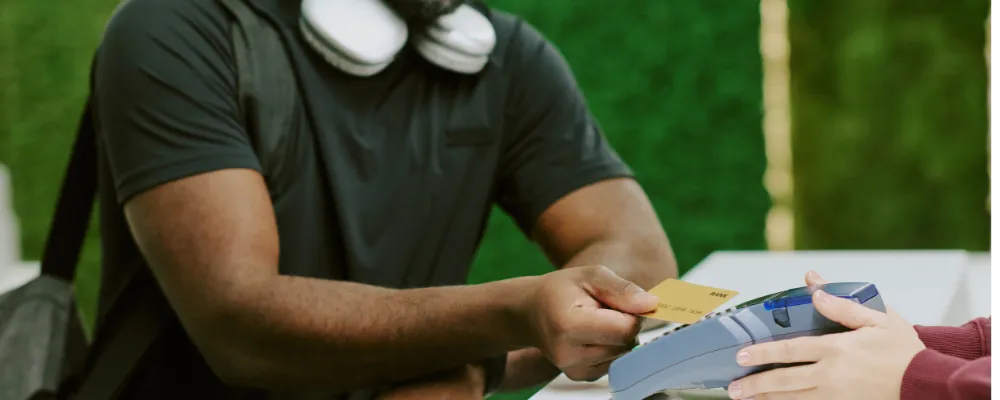 A customer using a credit card to pay a merchant using credit card fraud prevention tips for small businesses.