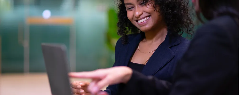 Two women deciding on a ACH, EFT, or Wire Transfer on a laptop.