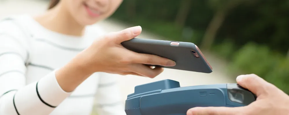 A woman using a mobile credit card reader for iPhone and androids.