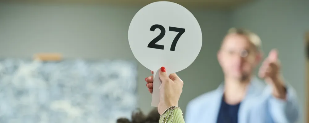 Employee holding up a paddle with their employee identification number.