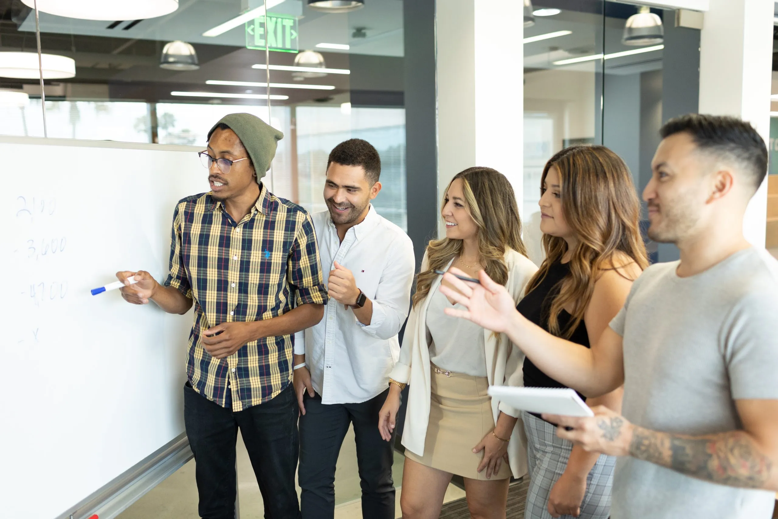 Co-workers reading the Kurv office whiteboard.