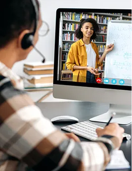 student taking notes while watching an online lecture