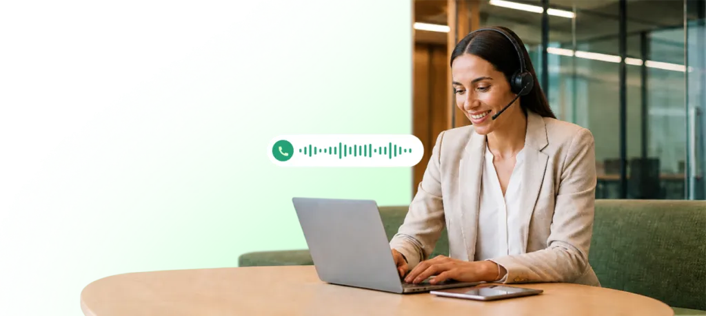 Customer support agent wearing a headset while working on a laptop with a call waveform icon displayed.