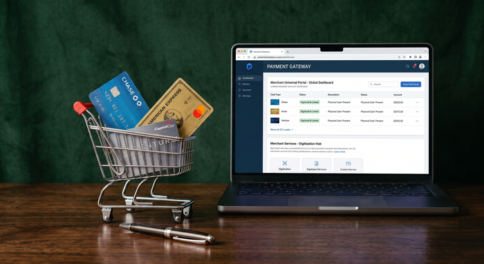 laptop with payment dashboard browser on screen and a small desk sized shopping with 3 credit cards inside.